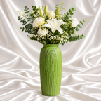 12-inch apple green decorative vase with vertical bark texture, styled with white lilies, roses and eucalyptus against draped white satin fabric.