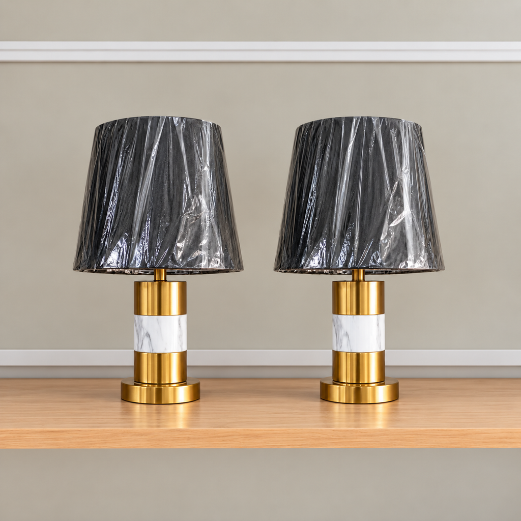 Pair of 28 inch luxury black and gold marble table lamps with black shades displayed on a white satin fabric background.