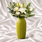 12-inch chartreuse green decorative vase with raised bark texture, holding white lilies, roses and eucalyptus on a white satin fabric background.