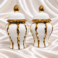 Set of two matching white decorative jars with lids and gold-tone accents