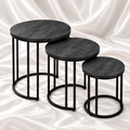 Set of three round matte charcoal nesting tables with slate-effect tops and black metal frames on white satin fabric