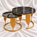Two black marble-effect nesting coffee tables with gold-tone rims, graduated rod detailing and open circular bases on white satin fabric.