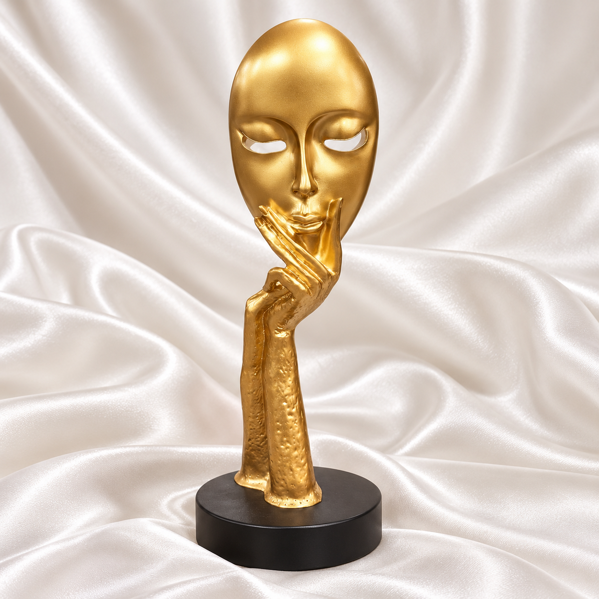Gold abstract face sculpture with hand-under-chin design and black circular base, displayed on white satin with the Decoreway logo.