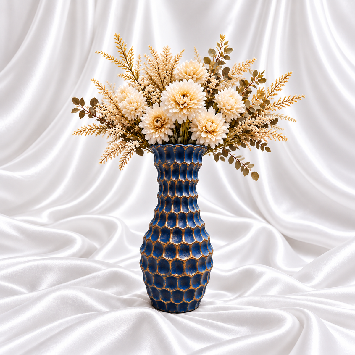 12-inch blue resin decorative vase with antique gold sculpted detailing, styled with cream flowers on white satin fabric. Flowers not included.
