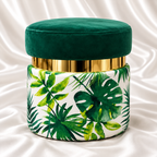Luxury emerald green velvet ottoman stool with tropical leaf print, shiny gold accent band and round upholstered design on white satin fabric – Decoreway.