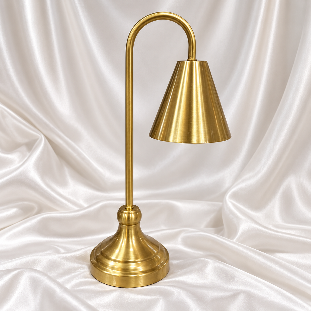 Luxury golden table lamp with elegant cone shade and curved stand on white satin background.
