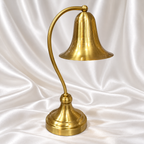 Luxury gold-tone table lamp featuring an elegant bell shade and curved decorative stand.